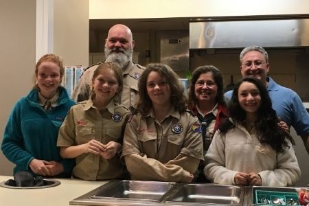 Scout girls and leaders serving food to help others