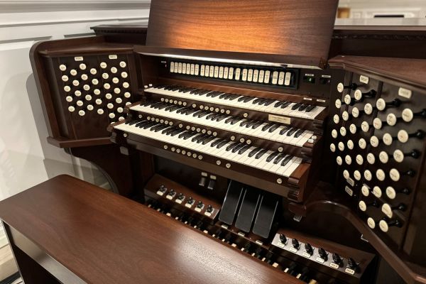 organ keyboard console with three levels of keys and many stops and foot pedals