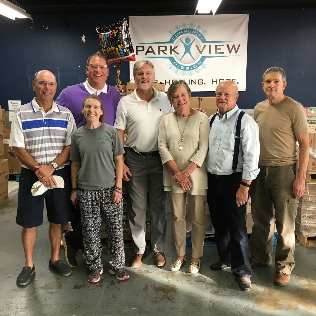 group of adults posing at ministry partner's warehouse