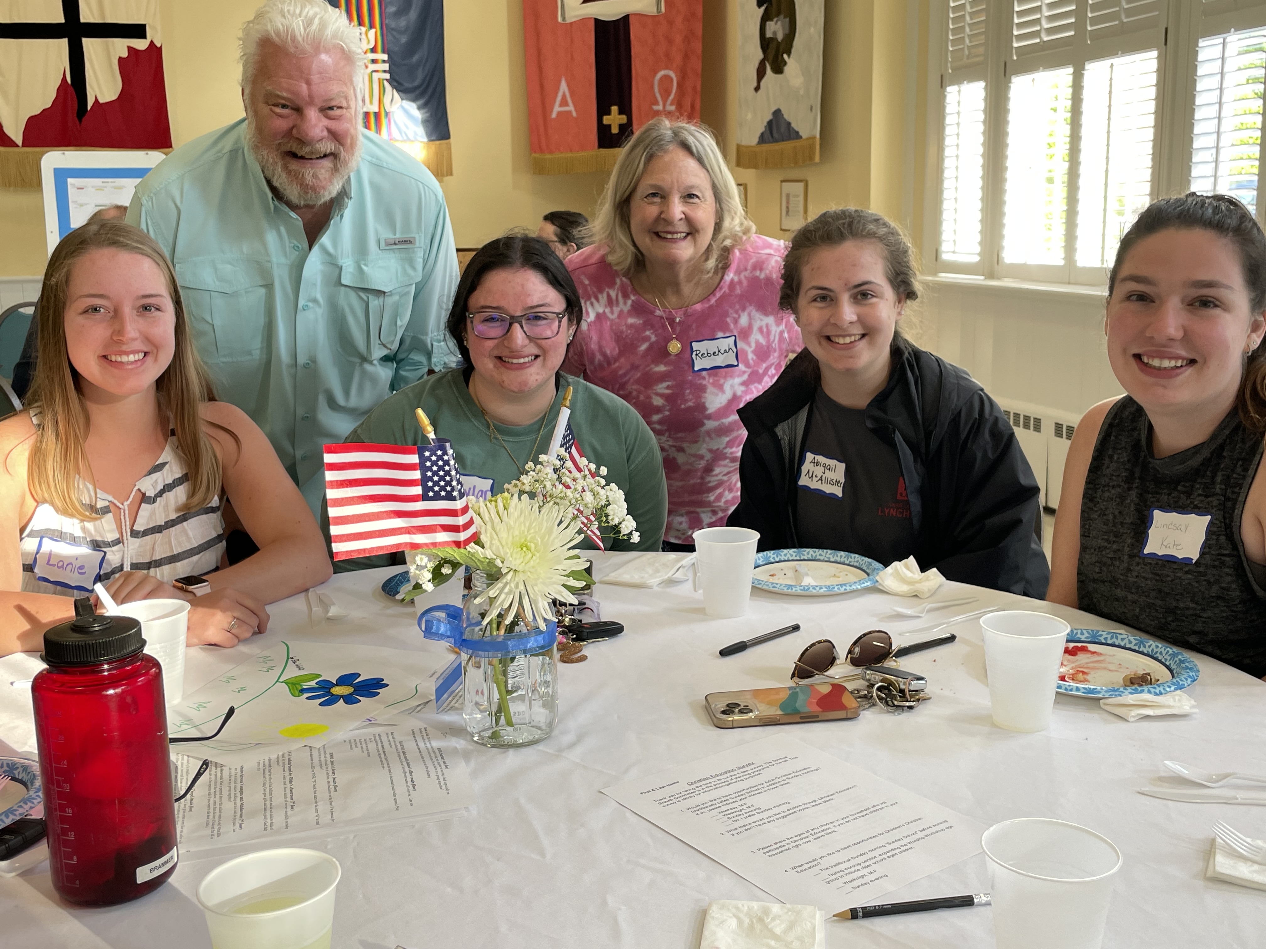 group of adults and college students gathered at a table to eat