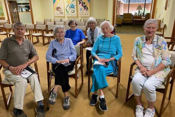 group of elderly, senior adults around a table signing cards for others