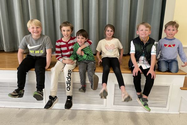 3 boys and 2 girls having a good time posing for a photo in the church