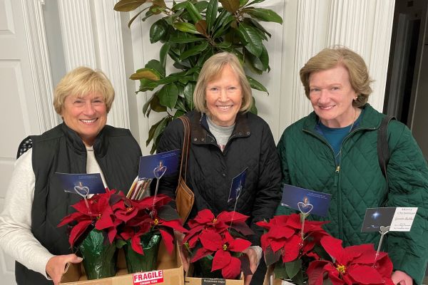 three ladies holding poinsettia plants to deliver to homebound and sick community members as part of Care and nurture life at First Presbyterian church lynchburg