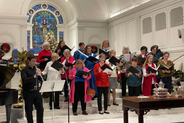 choir singing in preparation for worship with an oboist in the bottom left hand corner
