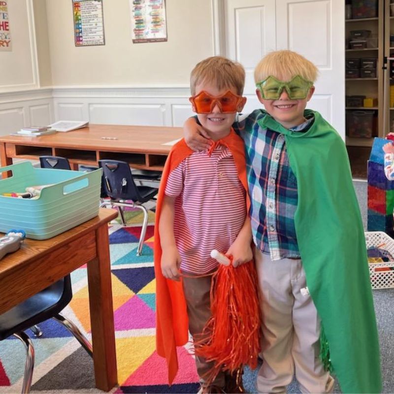 children outside lifting a blanket they made