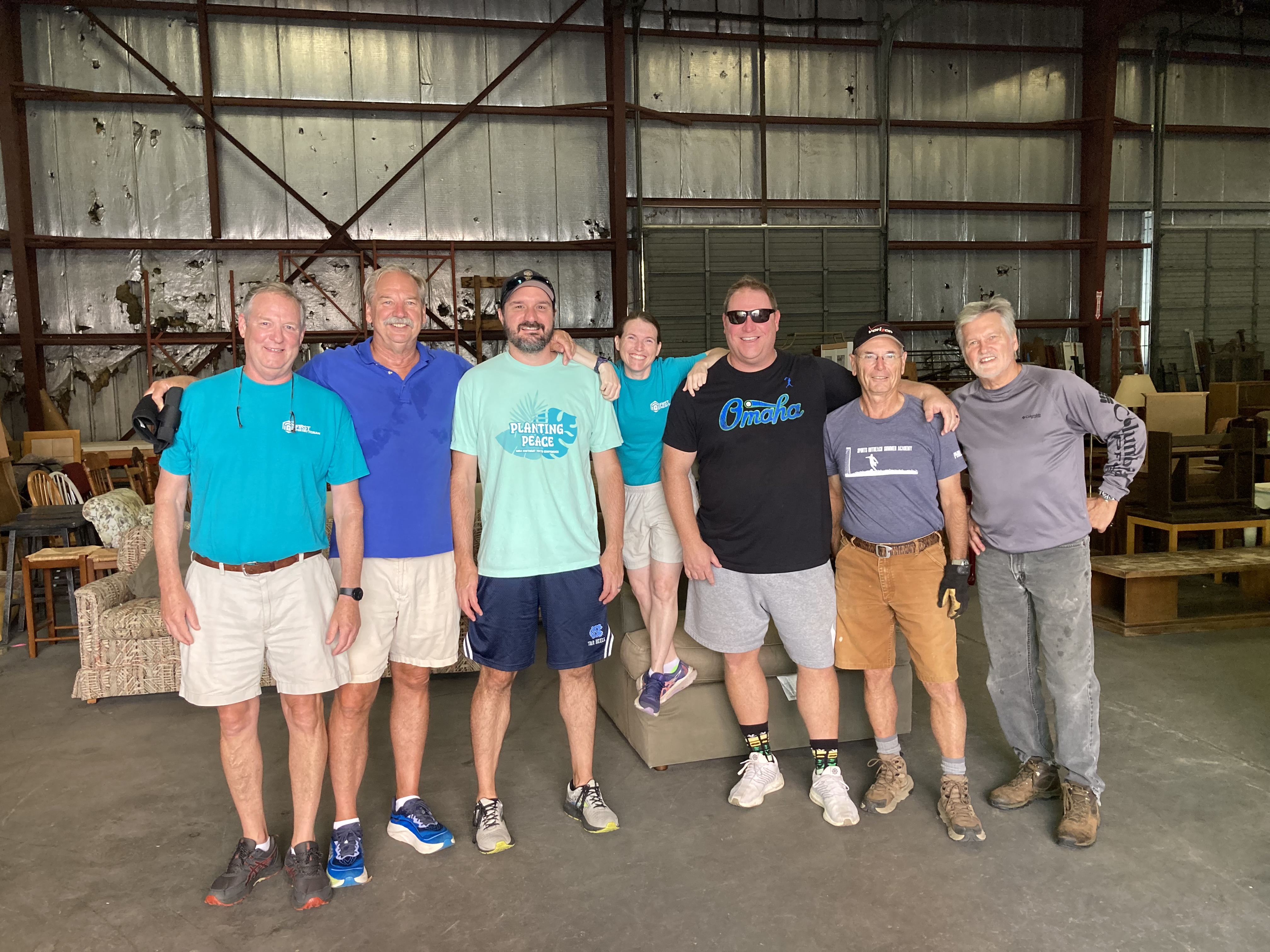 Alex Collier and other volunteers stand together at an IMPACT event