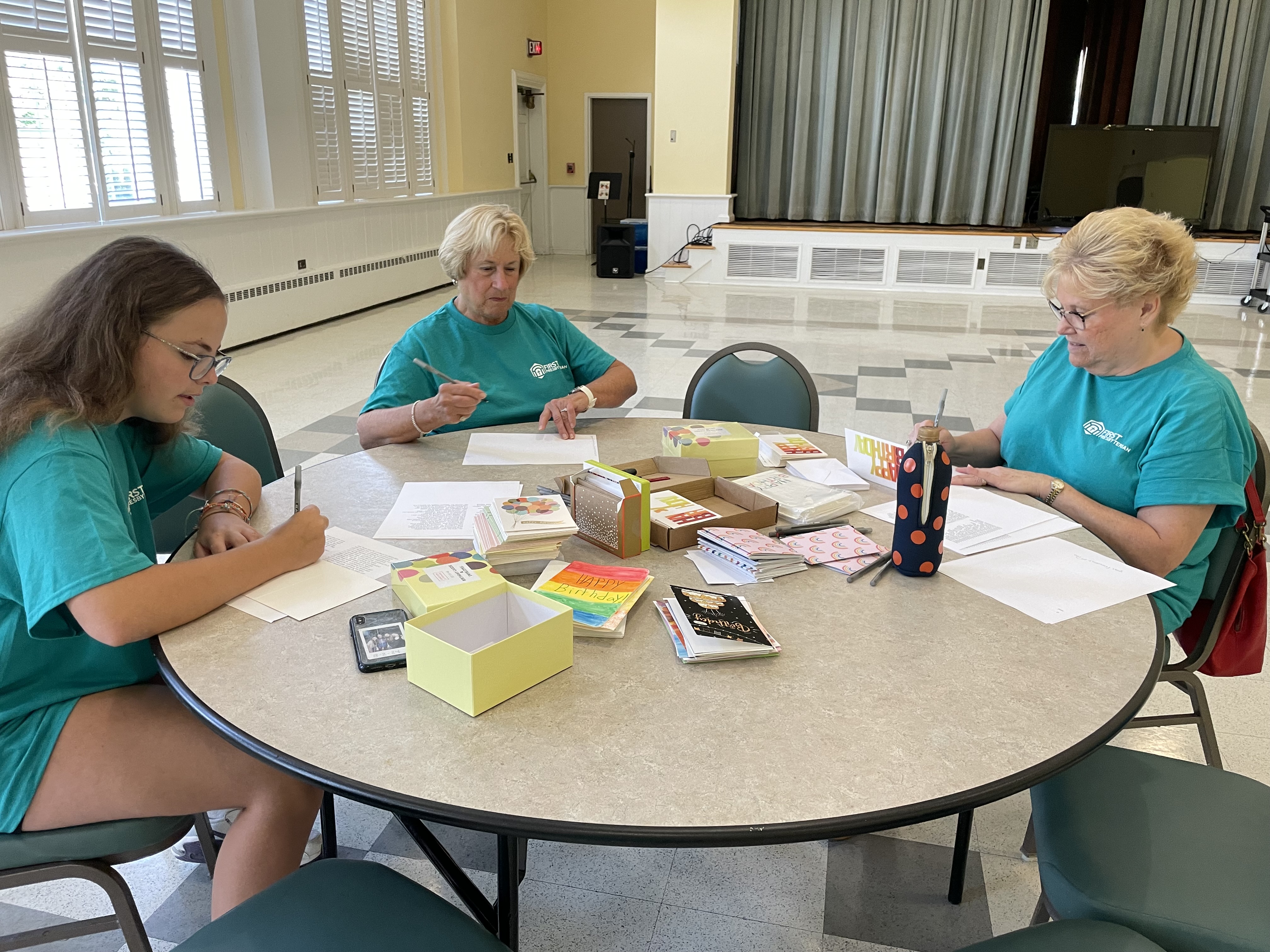 Ladies around a table writing letters and notes