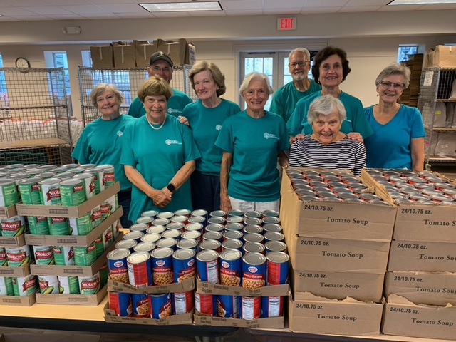 A group of volunteers with canned goods collected