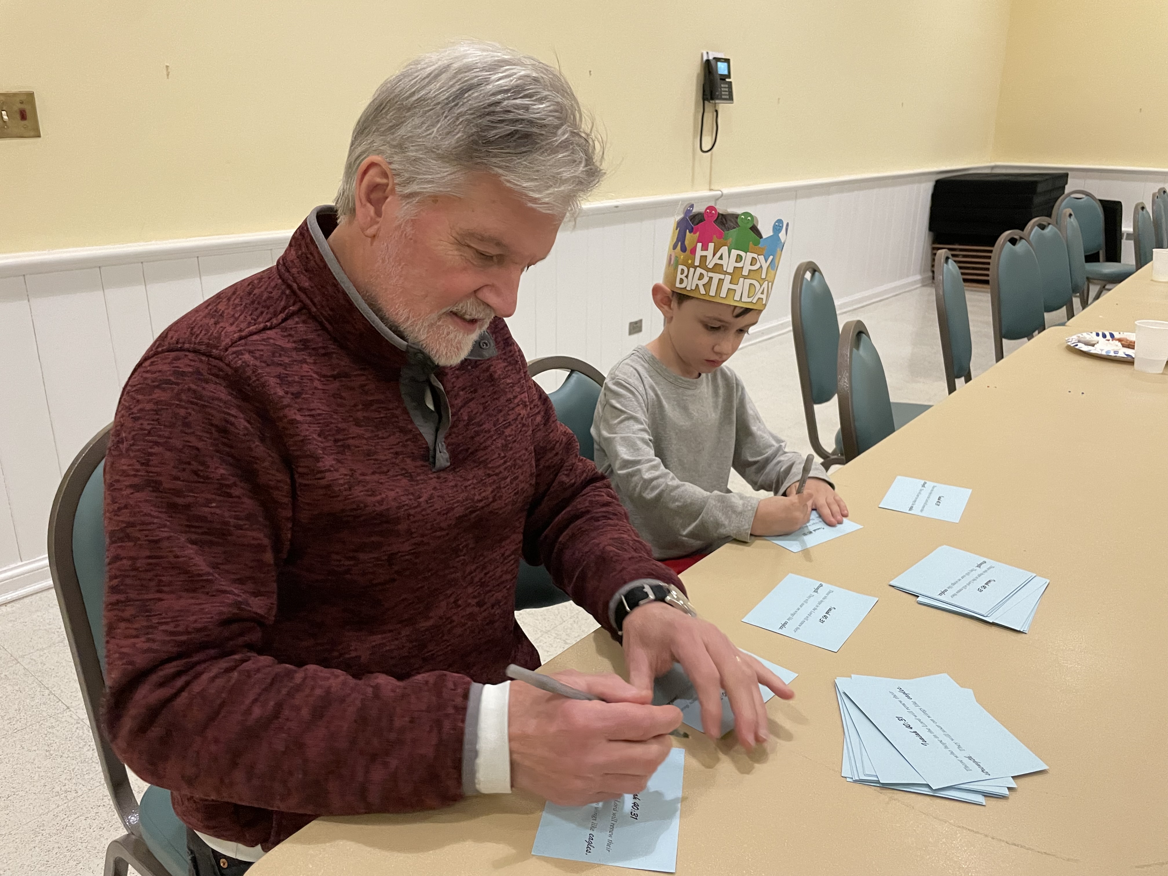 A man and a boy writing notes