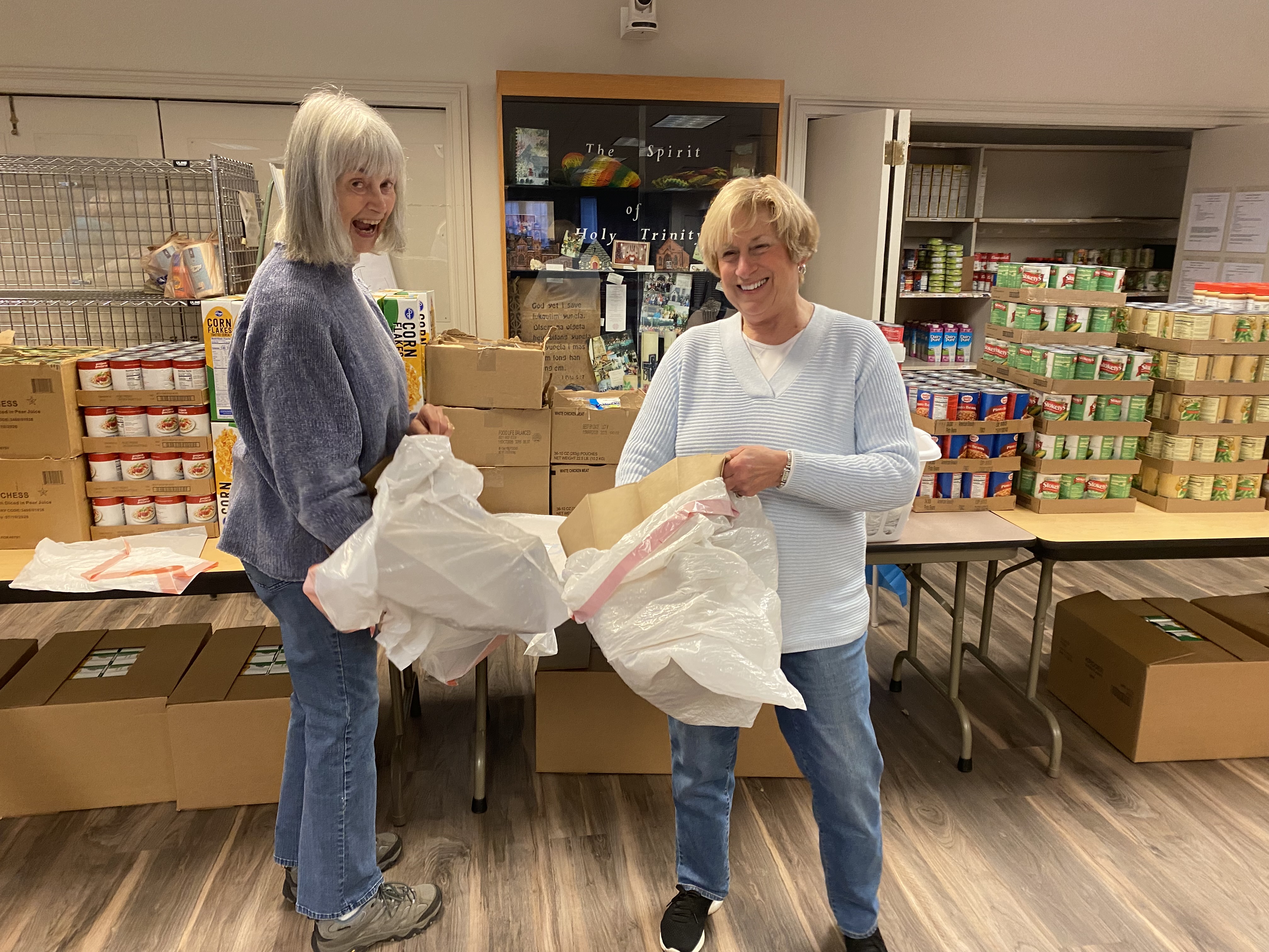 Two happy ladies helping with canned goods
